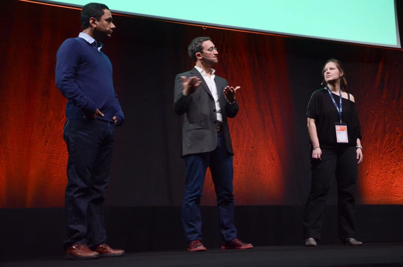 a group of people are standing on a stage