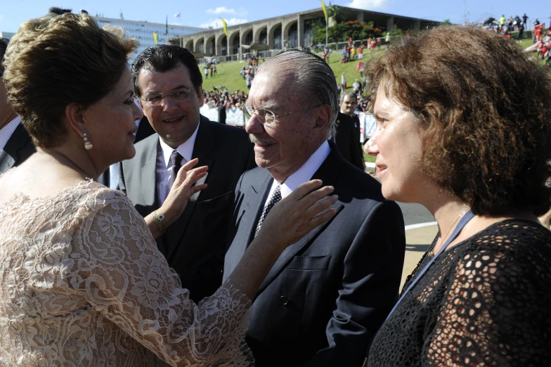 a man in suit standing next to a woman