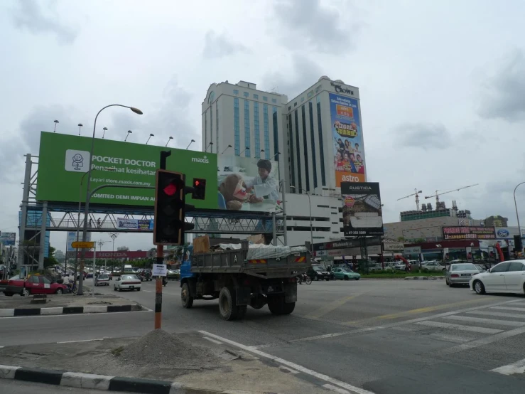 an utility truck driving on the road near a tall building