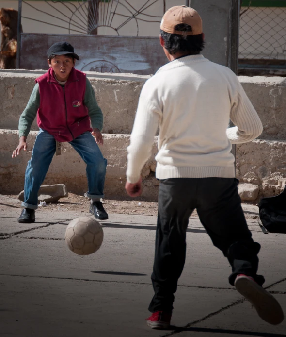 two young men playing with a ball in a courtyard