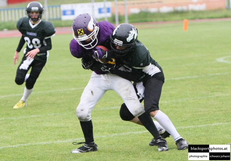 two football players are trying to tackle a ball