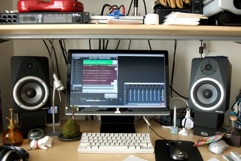 computer and speakers on a desk with shelves