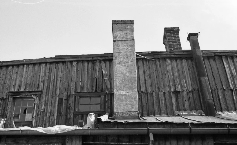 an old building with a chimney and a dog standing in front