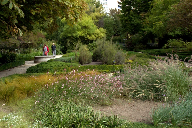 two people standing on the edge of an area near flowers