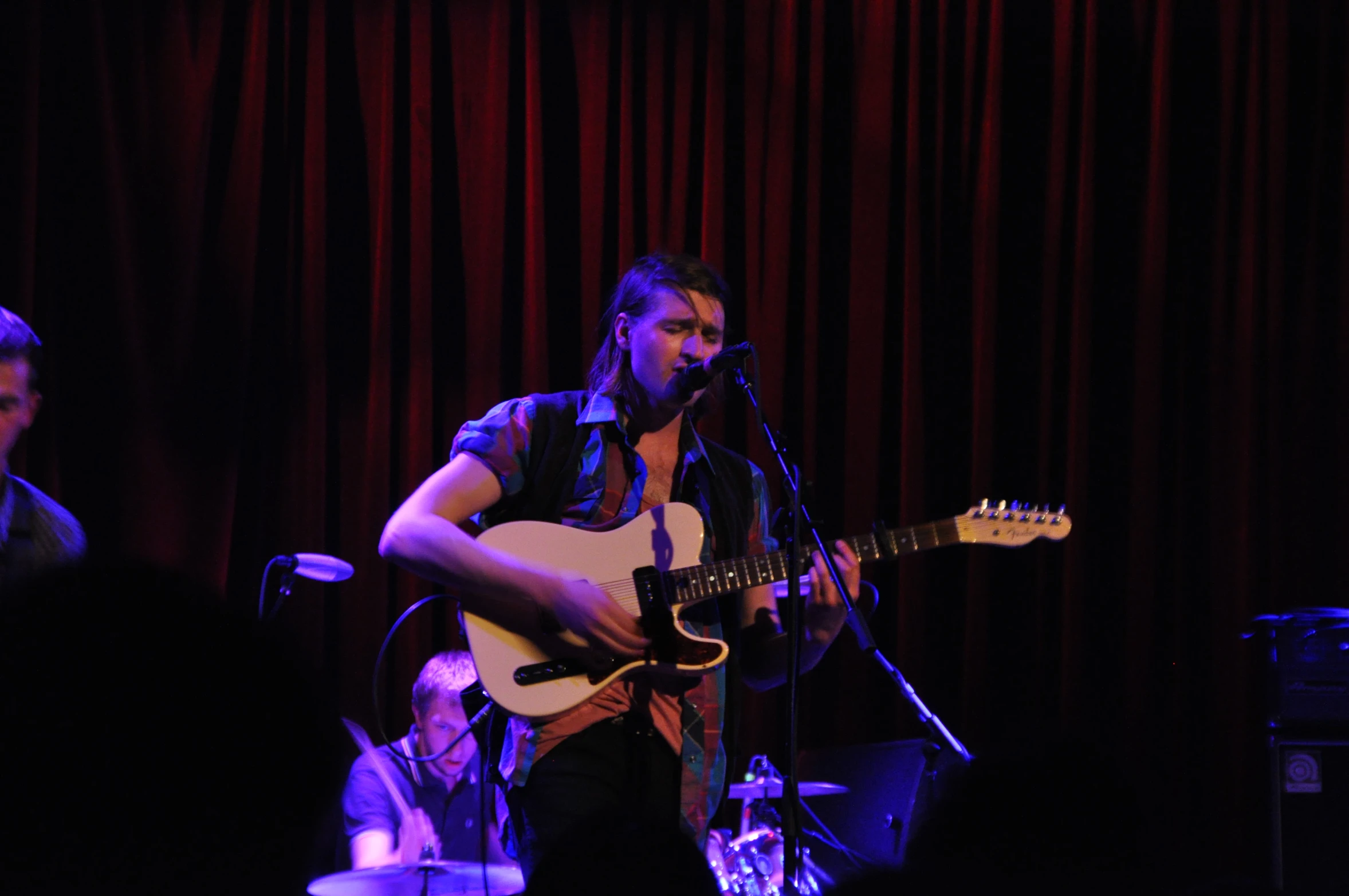 the man is playing his guitar on the stage