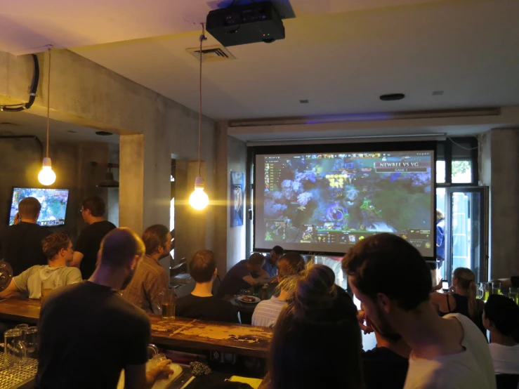 a group of people seated in a room with a projection on the wall