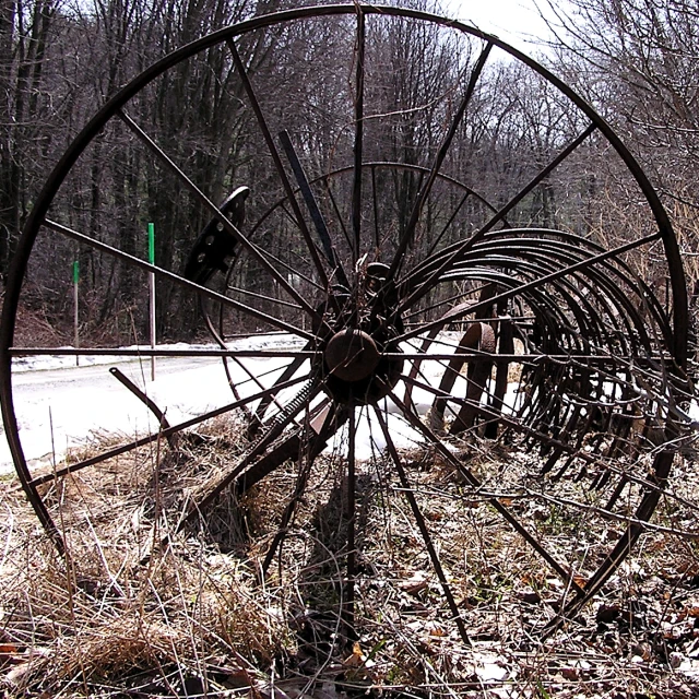 an old broken up wagon with wheels parked