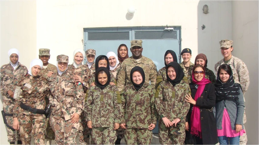 several people in camouflage poses for a po