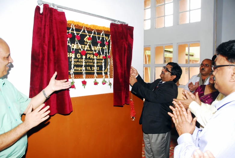 several men are attending to a presentation on red and gold decorations