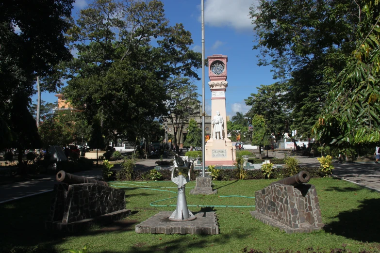 several small statues in a grassy area with trees