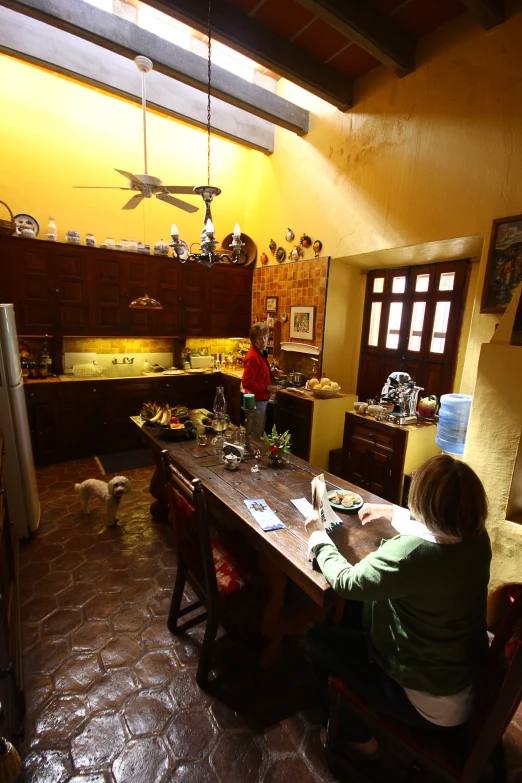 two people sitting at a table with plates in a kitchen