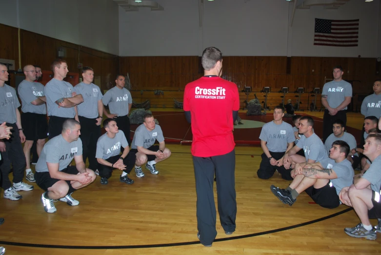 a group of men standing on top of a wooden basketball court