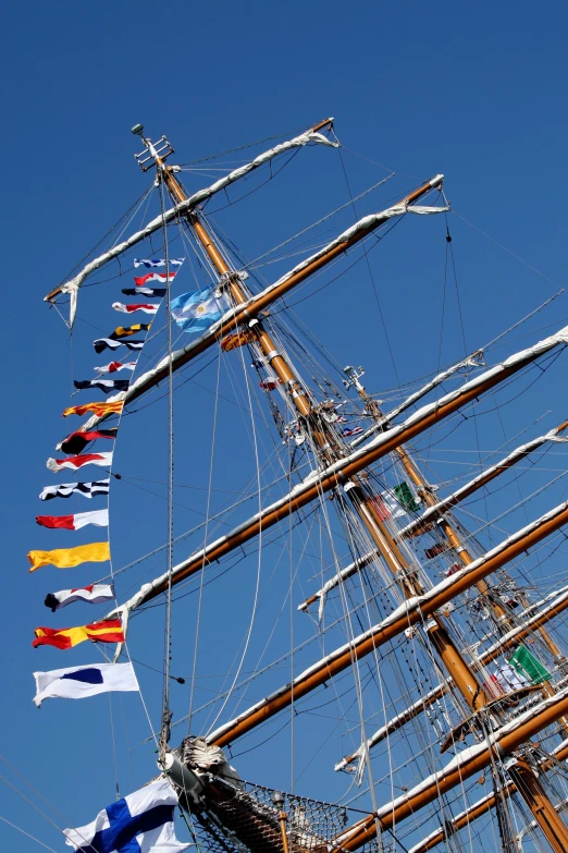 multiple colorful flags are hanging from the mast of a ship