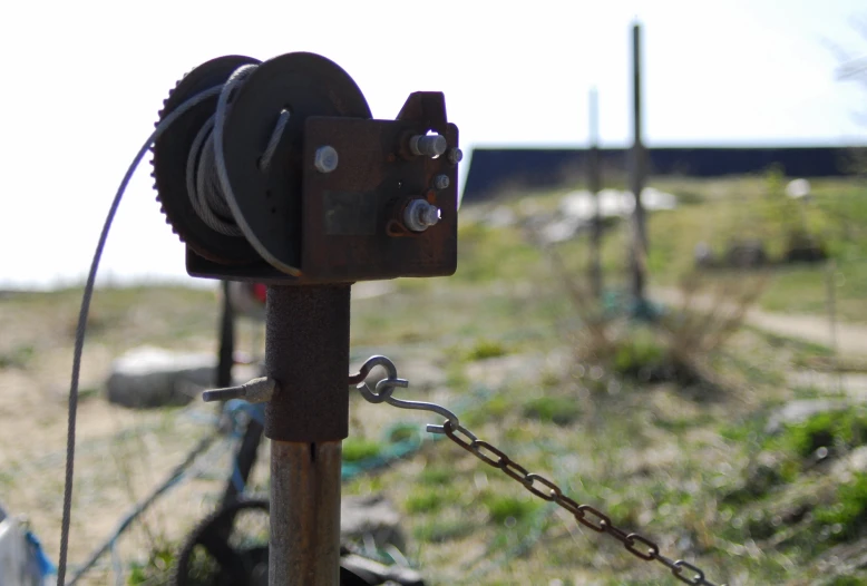 an old chain and padlock fence in a grassy field