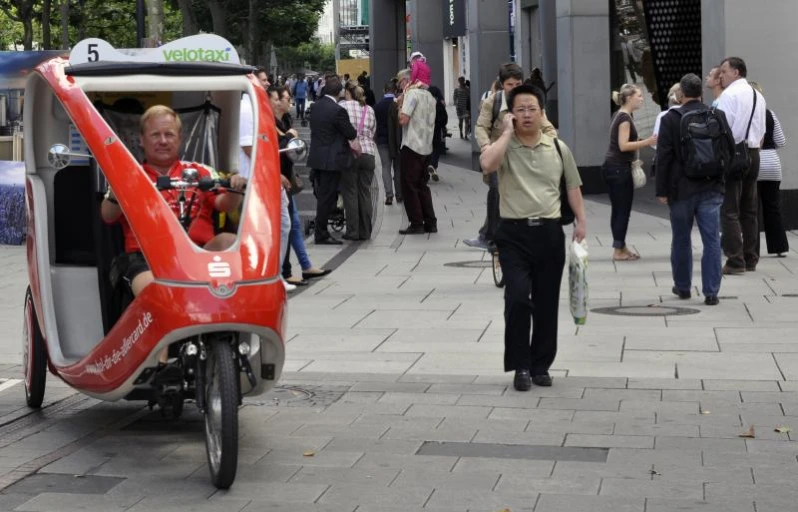 a small motorized vehicle on a street with people