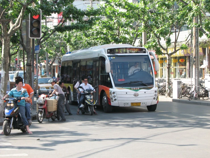 the city bus is on a busy street near many pedestrians