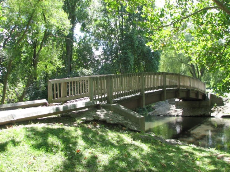 there is a wooden bridge that spans over a stream