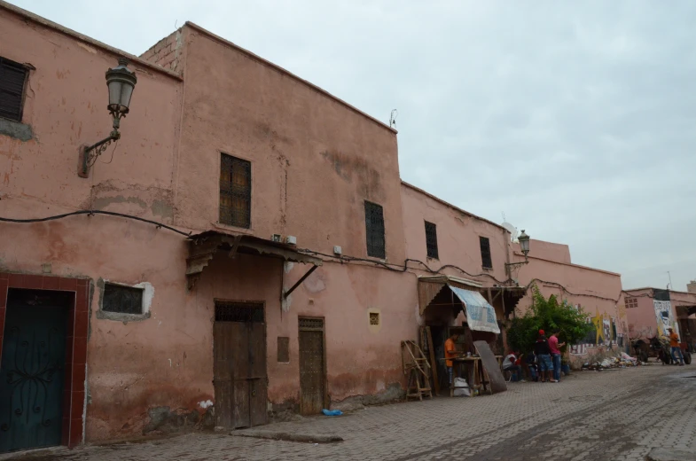 people gather at a street corner in an old town