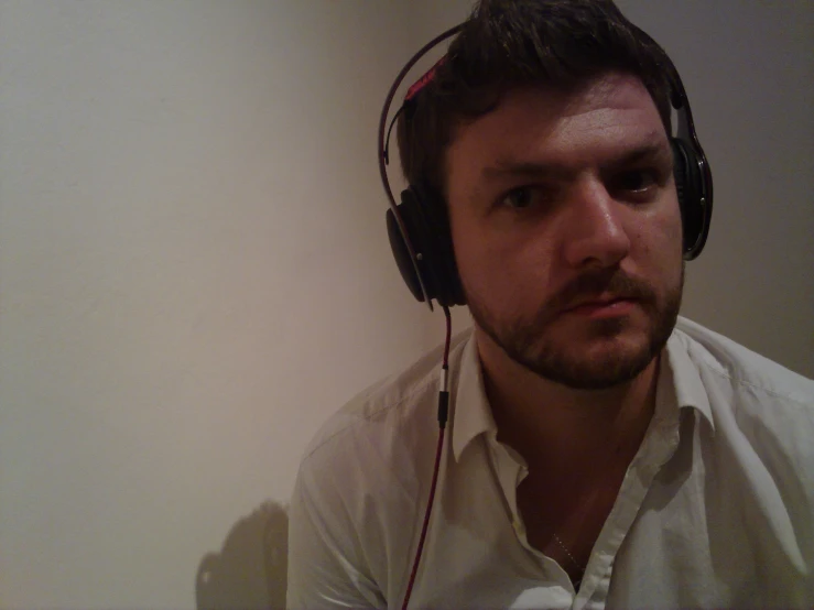 a man wearing headphones stares off into the distance