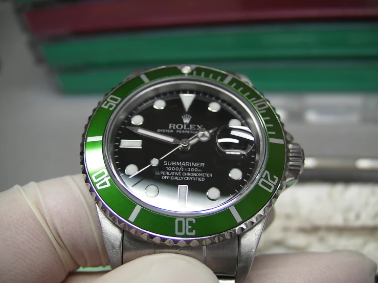 a rolex watch is shown with green bezel