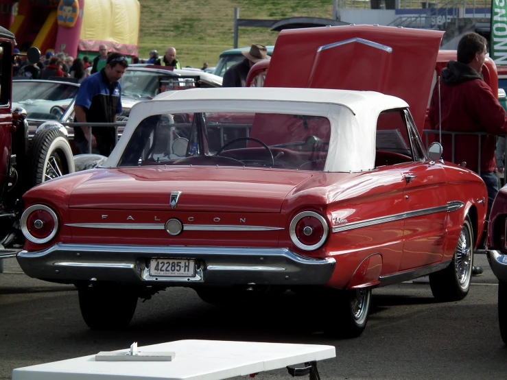 the red and white car is parked on the lot