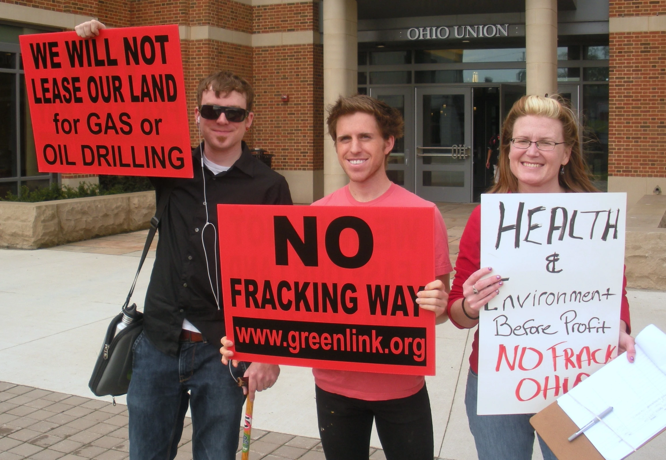 some people holding signs outside of a building