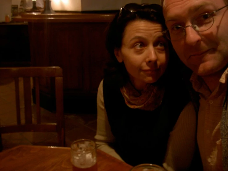 a man and woman sitting in front of drinks at a table