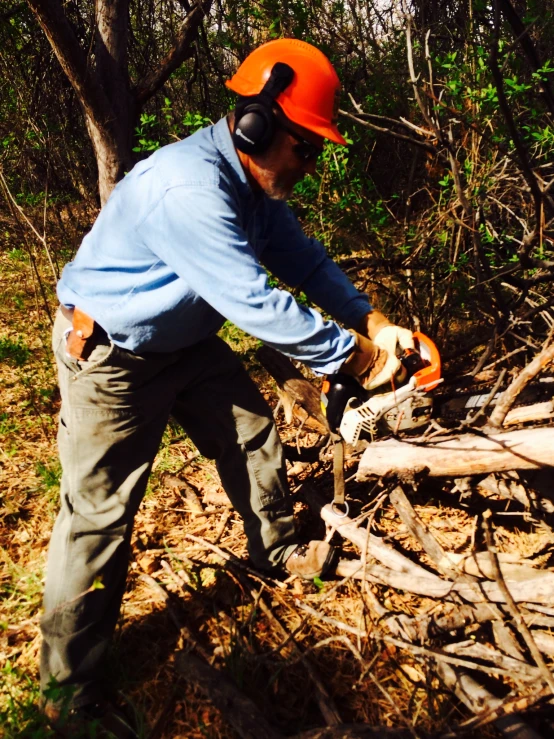 a man wearing a safety helmet and carrying a saw