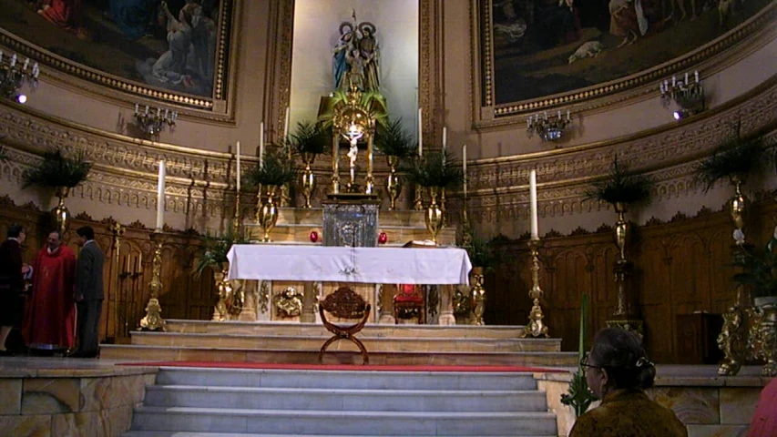 a priest standing at the back of some stairs