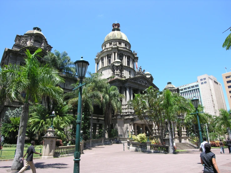 a tree lined area in front of a building with a large dome