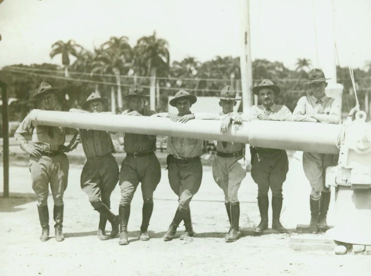 vintage black and white pograph of men holding an enormous bat