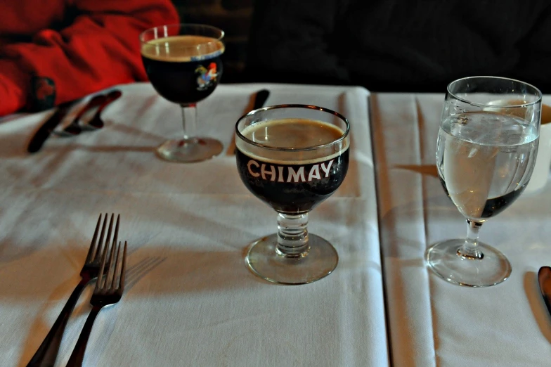 two glasses and some forks are on a table