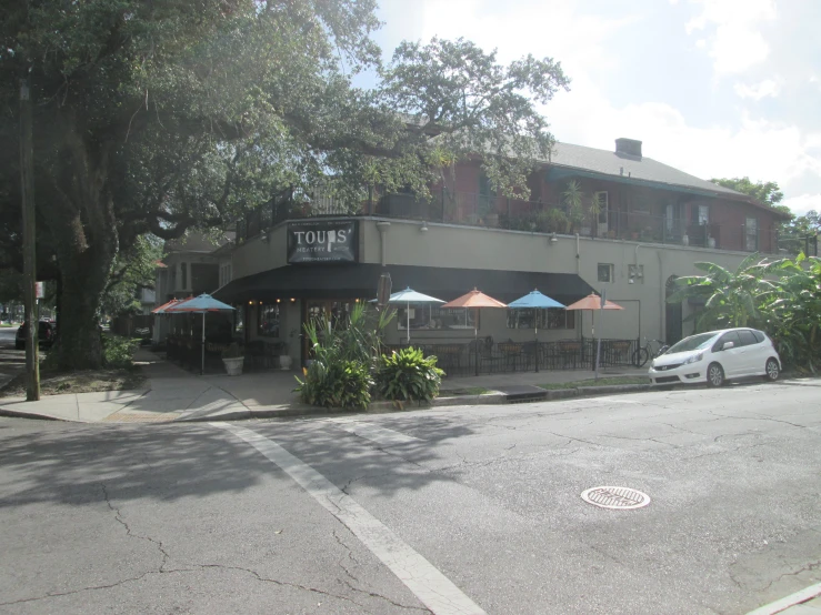 an umbrella line the side of a restaurant across from the street