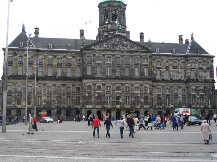 a crowd of people are gathered outside an old building