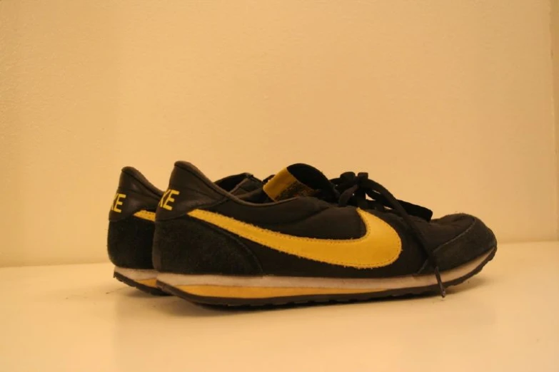 the shoe is in black and yellow with a white stripe