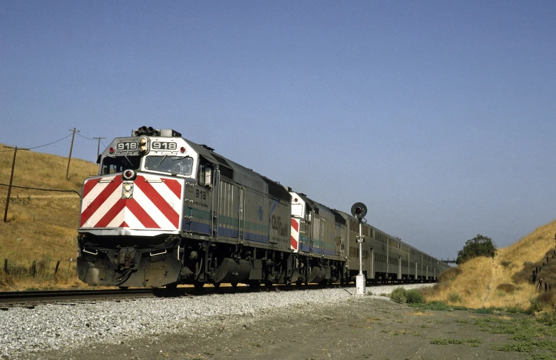 a train that is on some tracks by some grass