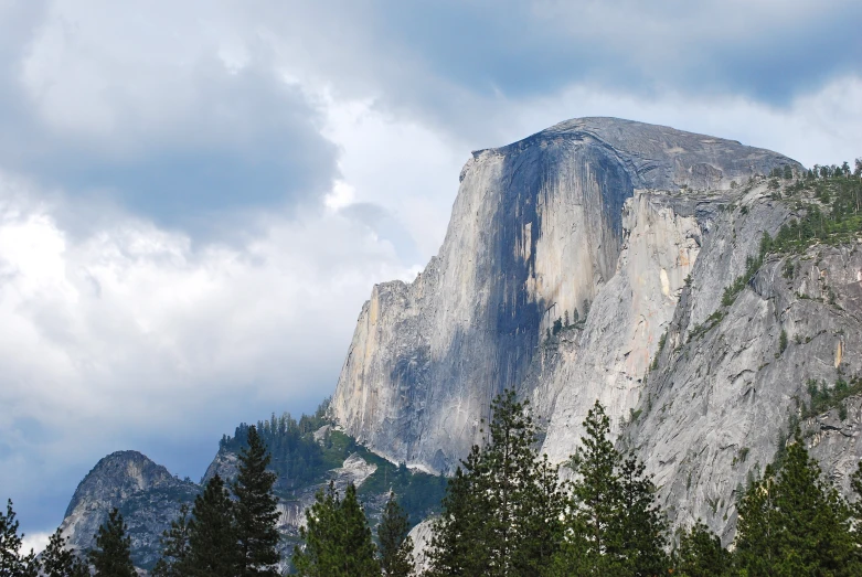 a very tall mountain surrounded by evergreen trees