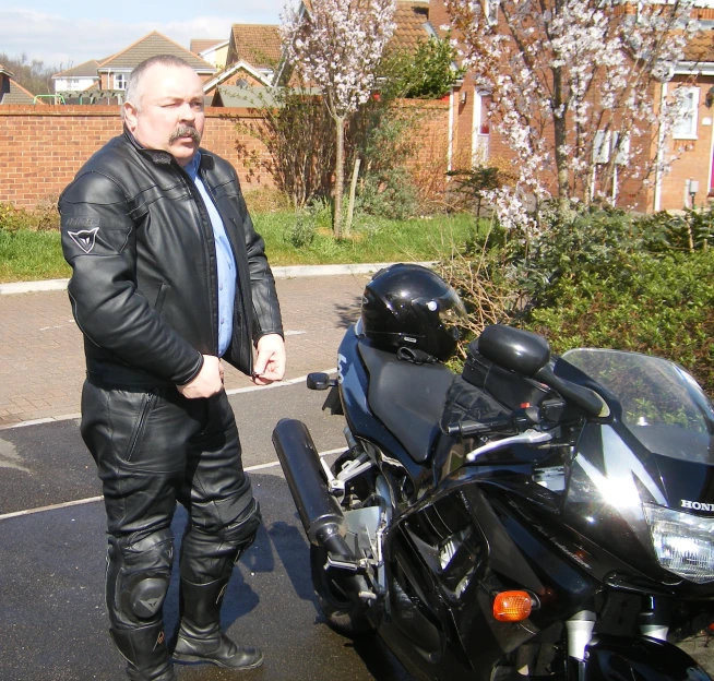 the man is standing next to his motorcycle