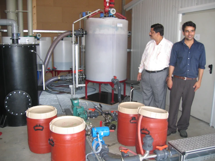 two men are standing next to water tanks