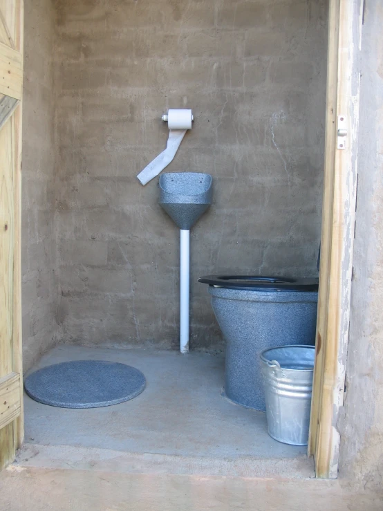 a toilet that is in a room with cement walls