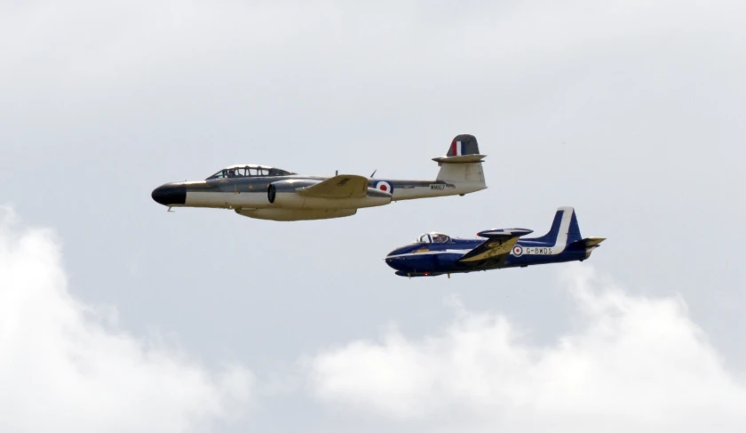 two airplanes flying overhead one is upside down