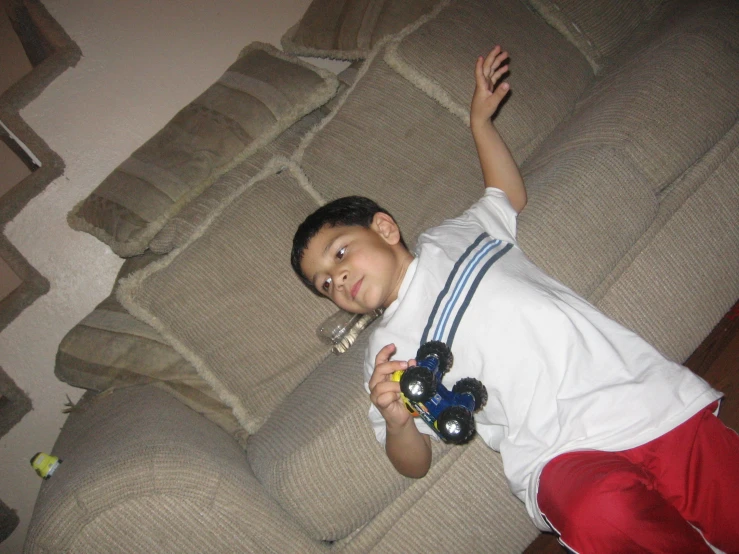a boy on a couch with a stuffed animal