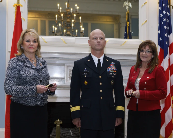the two woman standing next to an older military man