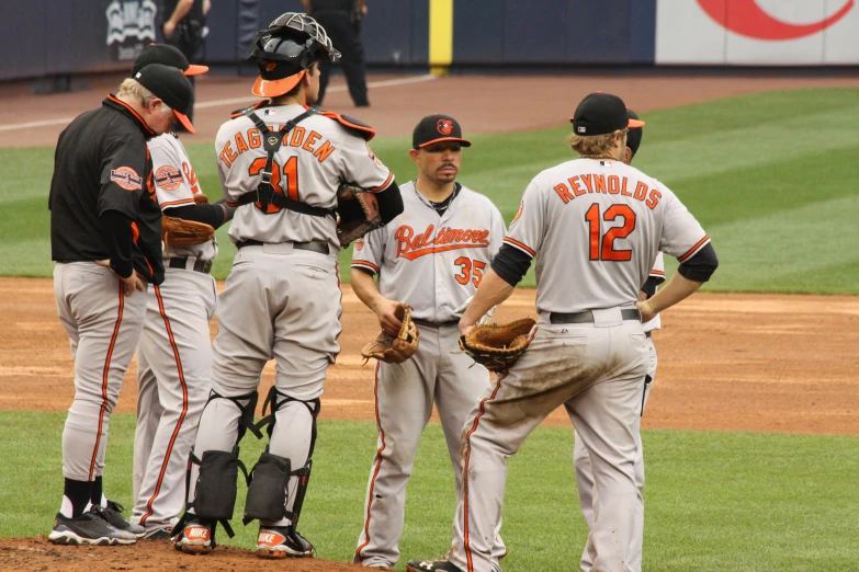 baseball players talking to each other on a baseball field