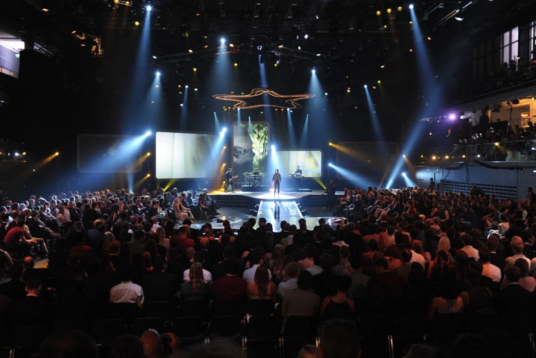 a crowd of people sitting in front of a stage