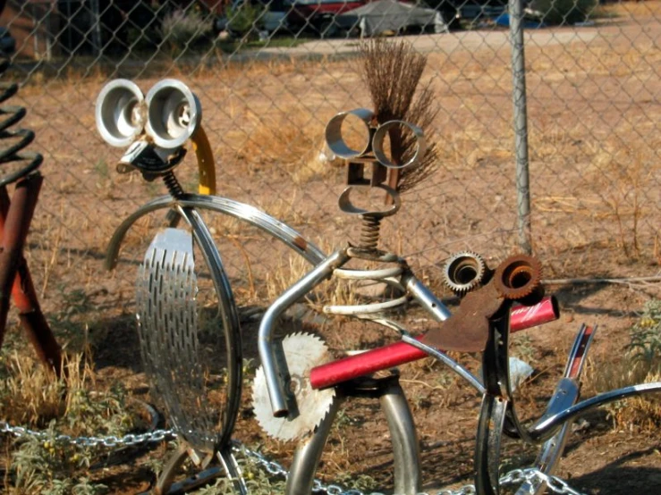 a fence has lots of assorted metal objects on it