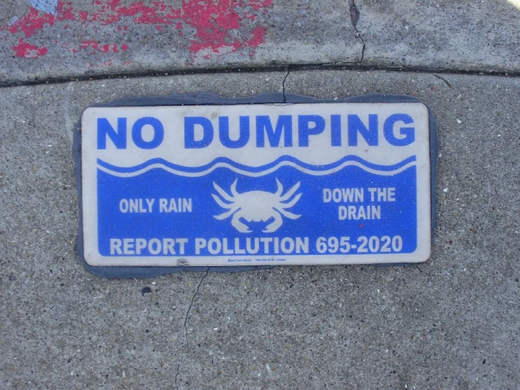 a sign is posted on a sidewalk in front of a pot hole