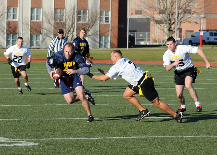 a football player in a white shirt is being blocked by two opponents