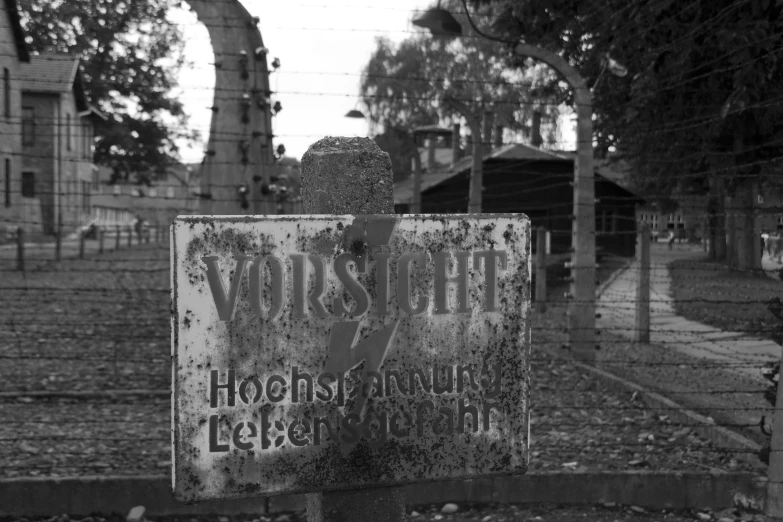 an old sign is leaning on a post