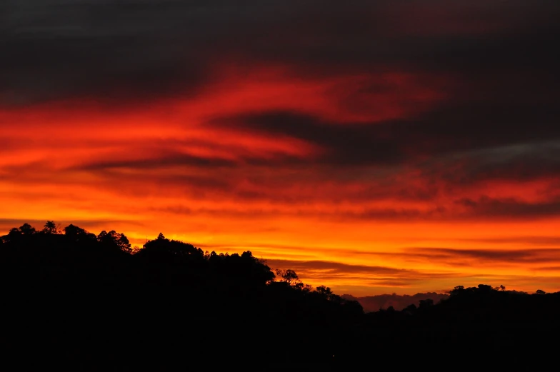 a plane flying through the sky at sunset